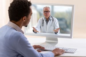 Telemedicine and health care concept with a young man and a doctor on computer screen